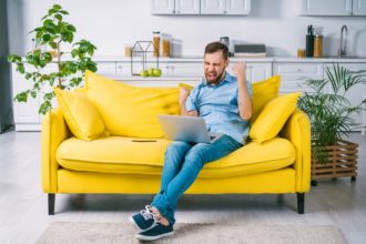 Čovjek koji se kladi preko laptopa