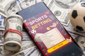 Mobitel s natpisom 'sports betting' na hrpi novaca (kako kladionice određuju koeficijente)