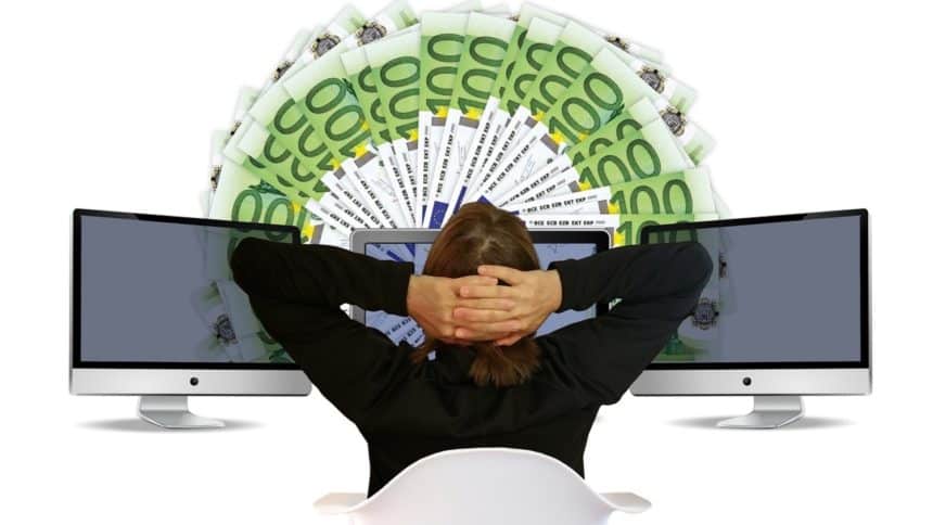 Osoba sjedi ispred monitora i novčanica (kako kladionice zarađuju)