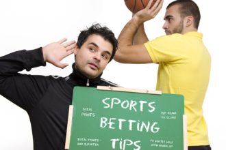 Muškarac drži ploču, košarkaš se priprema na šut (kako se kladiti na košarku)