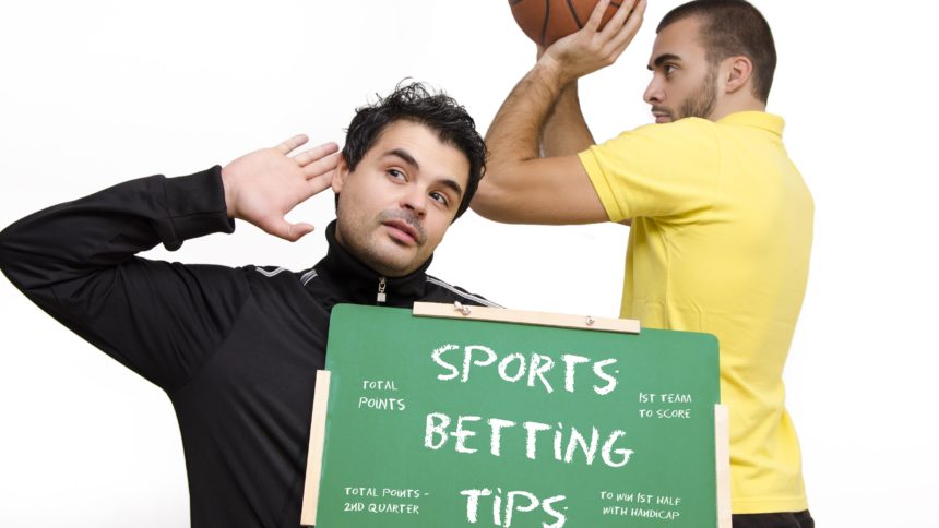 Muškarac drži ploču, košarkaš se priprema na šut (kako se kladiti na košarku)